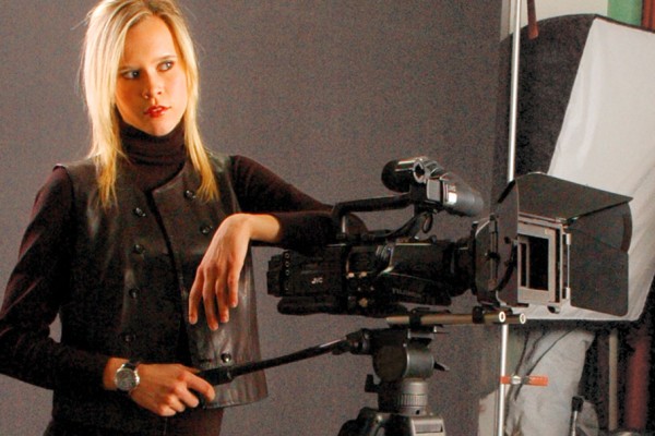 Blonde woman standing behind a camera