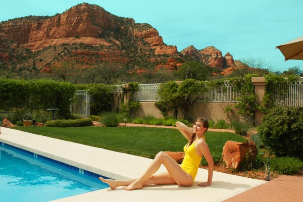 Young woman in yellow swimsuit sitting by the pool in Sedona