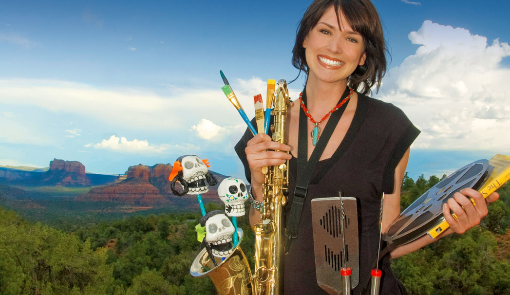 Brunette woman holding a variety of art supplies with the Sedona landscape in the background