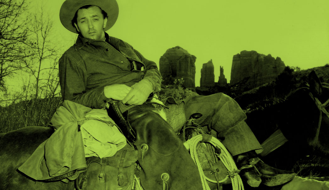 Robert Mitchum lounges at Red Rock Crossing while filming "Blood on the Moon" in early 1948.