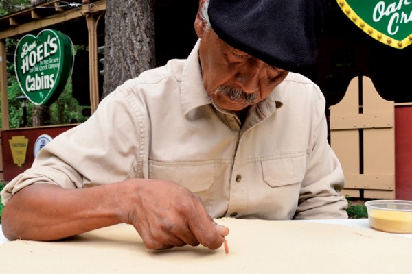 Older man wearing a beret while painting