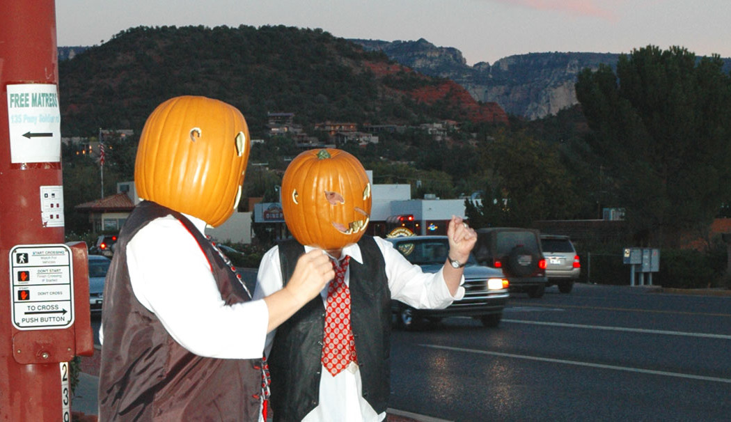 2 men in Sedona wearing pumpkins on their heads.